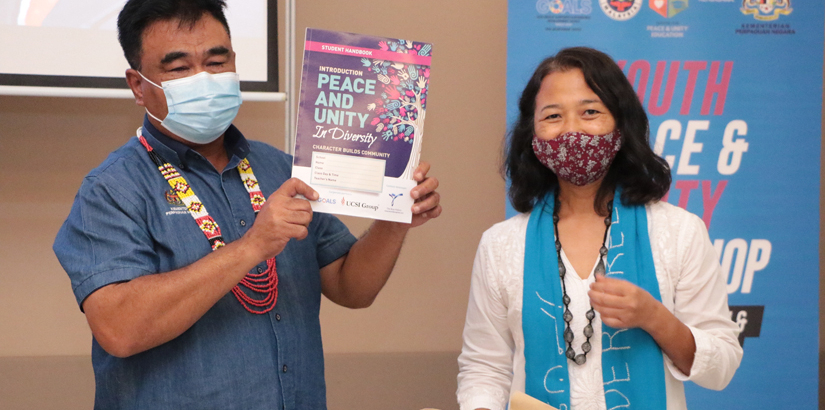 Norani Abu Bakar presents the Peace and Unity book.